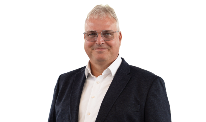 Ein Mann mittleren Alters mit hellem Haar trägt Brille und einen Anzug.