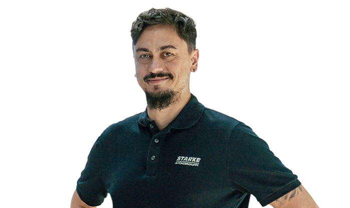 Ein junger Mann mit dunklem Haar trägt ein schwarzes STARKE Polo-Shirt..
