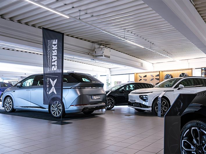 XPENG Fahrzeuge in einem Showroom mit Ausstellungsfläche, Markenbanner und Fahrzeugpräsentation.