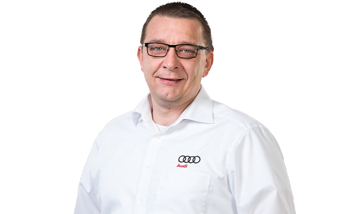 Portrait eines Mitarbeiters mit kurzem Haar in einem weißen Hemd.