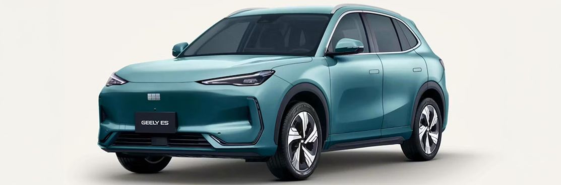 Geely E5 Max+ in türkisgrüner/petrol Lackierung in Frontseitenansicht vor neutralem hellem Hintergrund.