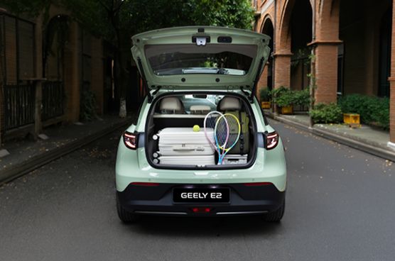 Geöffneter Kofferraum des Geely E2 mit Reisegepäck, Tennisschlägern und weiteren Gegenständen.