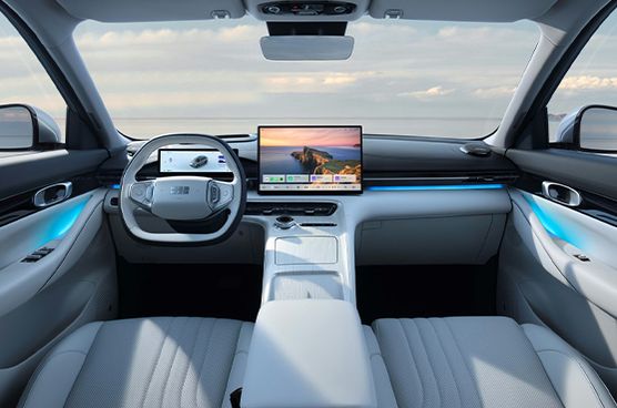 Innenraum des Geely E5 mit hellem, perforiertem Lederbezug, ausgeklappter Mittelarmlehne und blauer Ambientebeleuchtung an der Türverkleidung.
