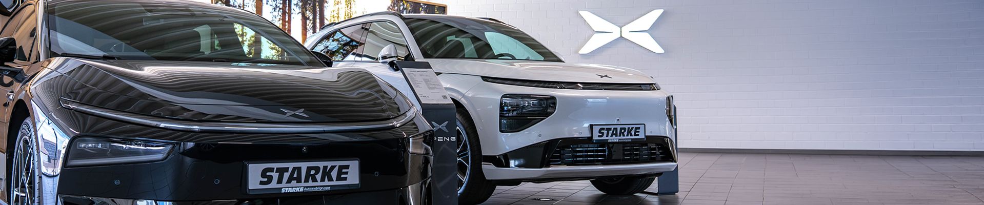 Schwarzer XPENG P7+ und weißer XPENG G9 in einem Showroom mit Markenlogo im Hintergrund.