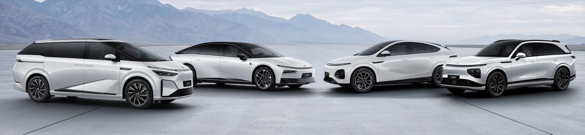 Vier weiße XPENG Elektrofahrzeuge aus verschiedenen Fahrzeugklassen stehen nebeneinander auf einer offenen Fläche vor einer Berglandschaft. Zu sehen sind ein Van, eine Limousine sowie zwei SUV-Modelle der XPENG Modellpalette.