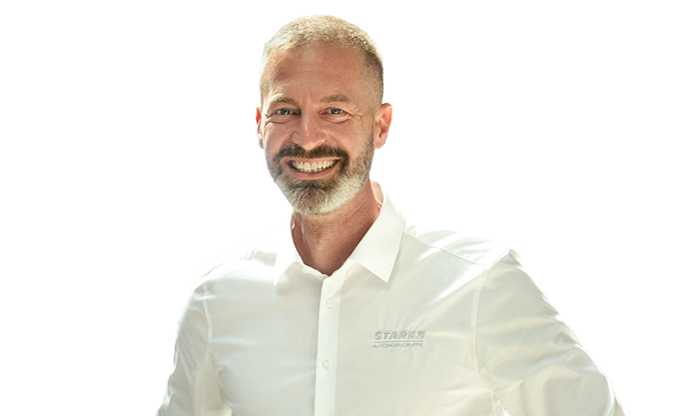 Ein Mann mittleren Alters trägt ein weißes STARKE Hemd.