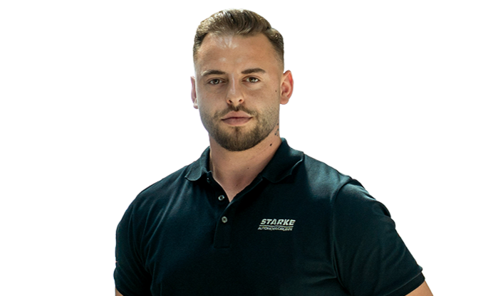 Ein junger Mann mit dunklem Haar trägt ein schwarzes STARKE Polo-Shirt.