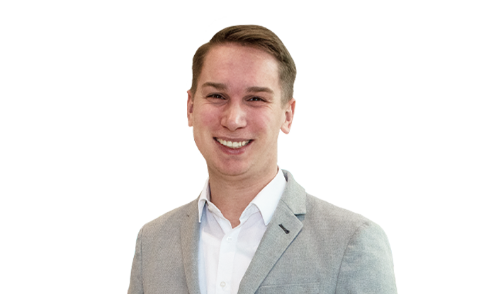 Portrait eines Mitarbeiters mit kurzem Haar in einem weißen Hemd und hellgrauem Jackett.