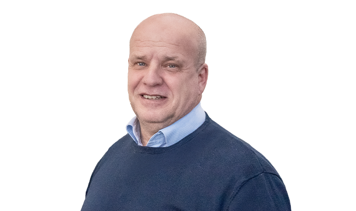 Portrait eines Mitarbeiter in einem blauen Pullover mit hellblauem Hemdkragen.