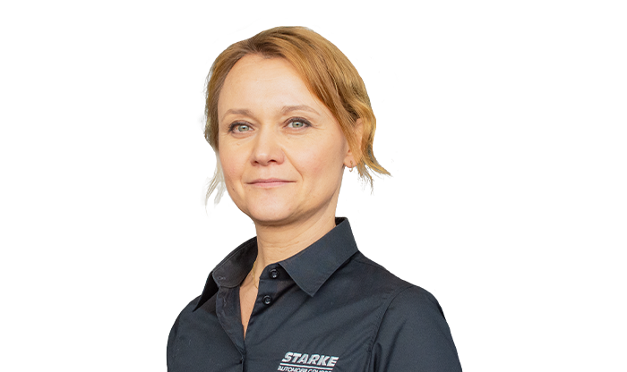 Portrait einer Mitarbeiterin mit hochgesteckten Haaren und einer schwarzen Bluse. 