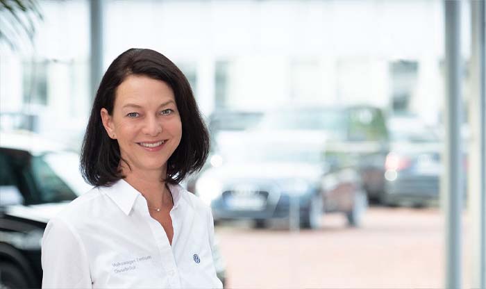 Portrait einer Mitarbeiterin mit mittellangem Haar und einer weißen Bluse.