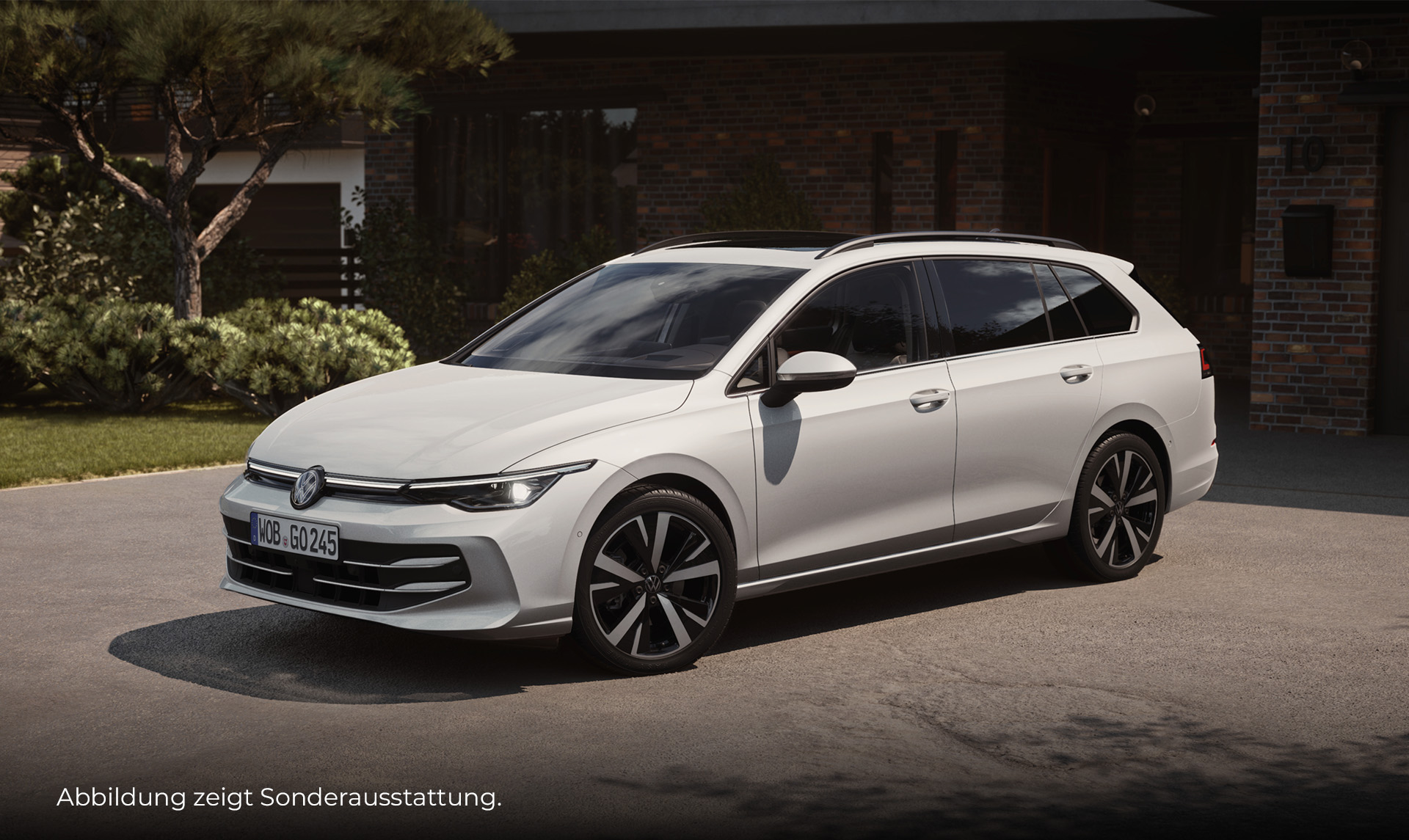 Ein weißer VW Golf Variant steht seitlich in einer Hofeinfahrt. Im Hintergrund sieht man ein verklinkertes Haus sowie Garten und Bäume. Unten links im Bild steht der Hinweis: "Abbildung zeigt Sonderausstattung".