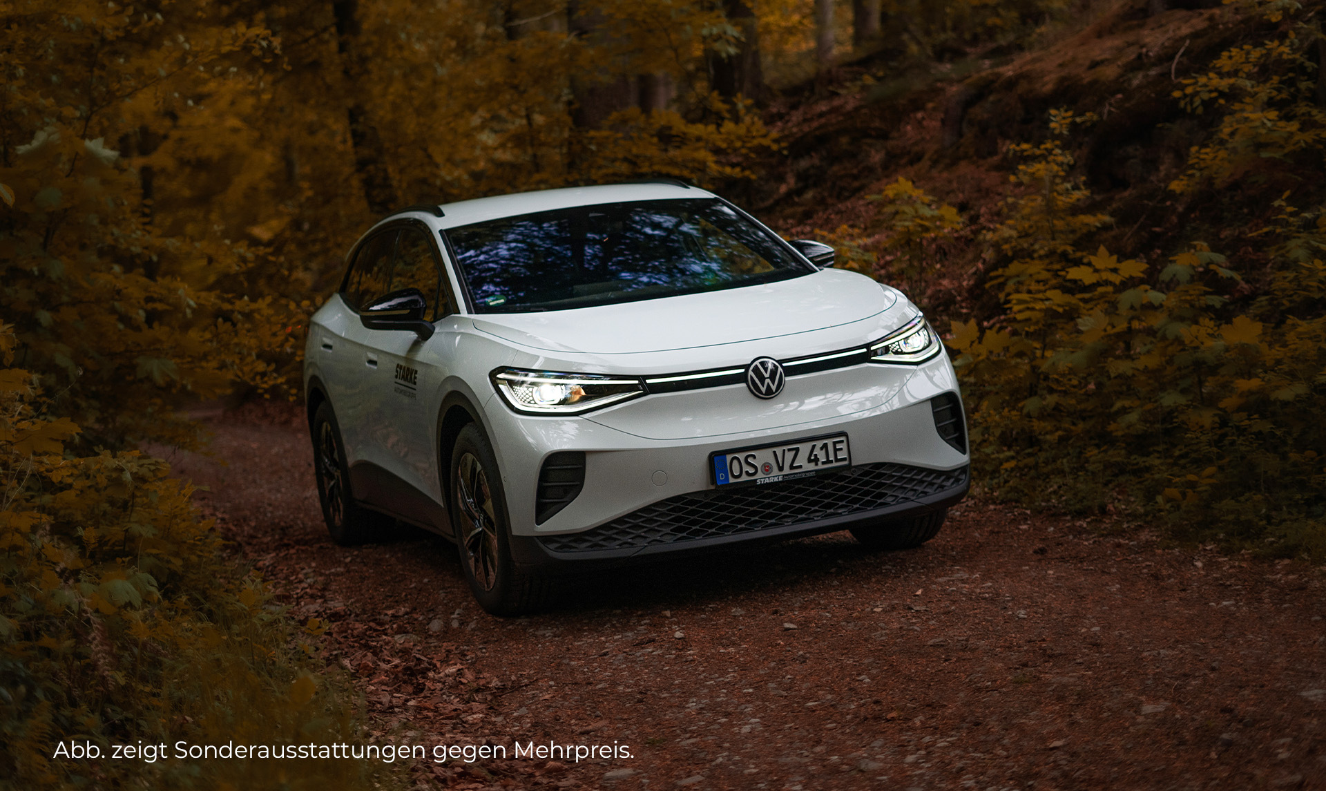 Das Bild zeigt einen weißen ID.4 you in einem herbstlichen Wald. Zu sehen ist der ID.4 you von vorne und von der rechten Seite.