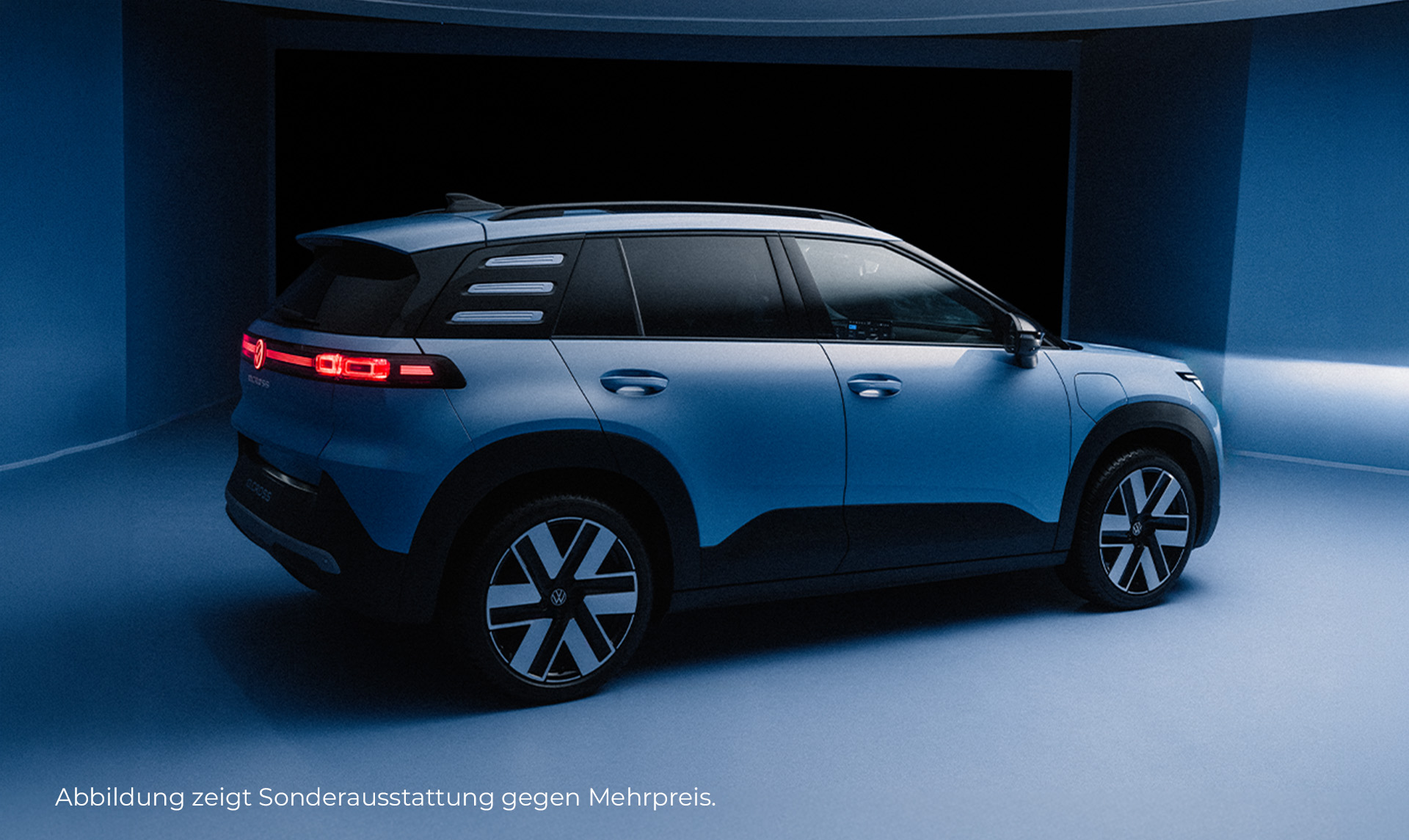 Ein blauer ID. Cross steht leicht schräg in Fahrtrichtung rechts in einem bläulichen Raum. 